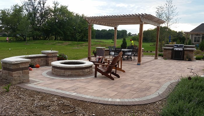 Pit fit on patio with stone bench and pergola